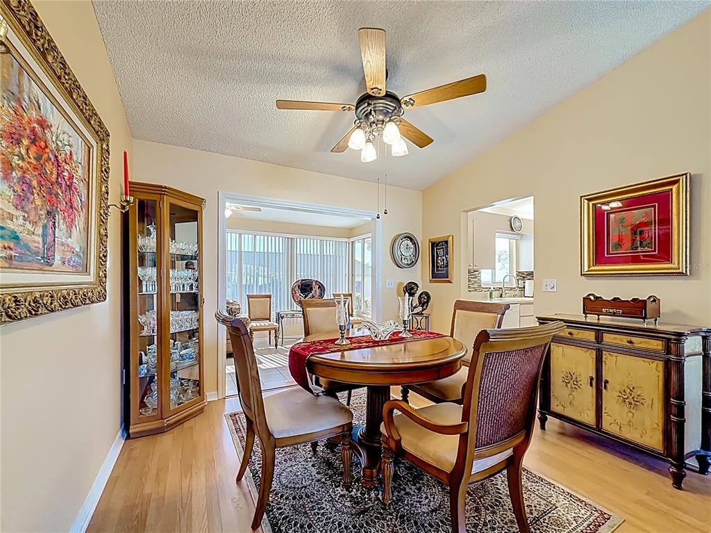 A front porch features a white storm door with a wreath, siding, and brick accents — 9826 SE 178TH LANE, SUMMERFIELD, FL