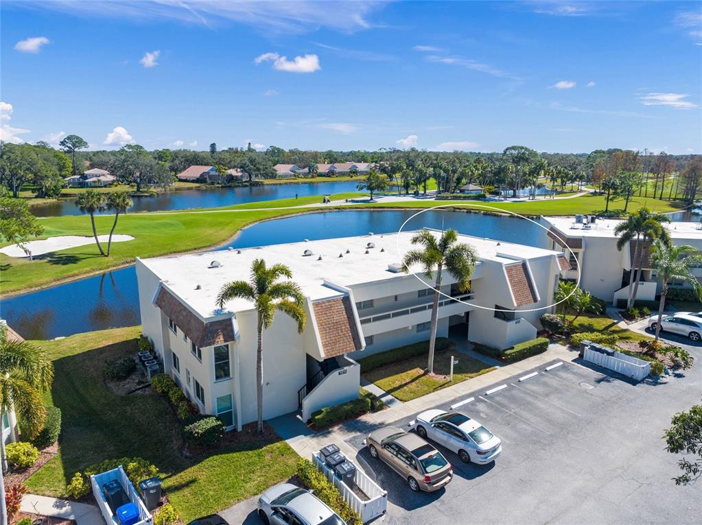 An aerial view shows a multi-story apartment building with a flat roof near a lake — 7193 W COUNTRY CLUB DRIVE N UNIT 237, SARASOTA, FL