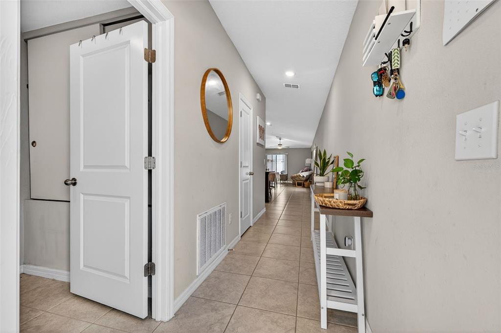 A hallway with tile flooring leads from an entryway toward a living area — 9324 LEMON DROP LOOP, SUN CITY CENTER, FL