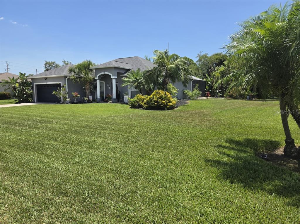A gray single-story house with a two-car garage and palm trees in the front yard — 1604 21ST AVENUE W, PALMETTO, FL