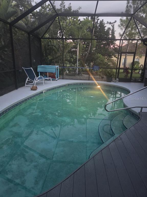 A screened-in swimming pool with a gray deck and a lounge chair under a lanai — 1604 21ST AVENUE W, PALMETTO, FL