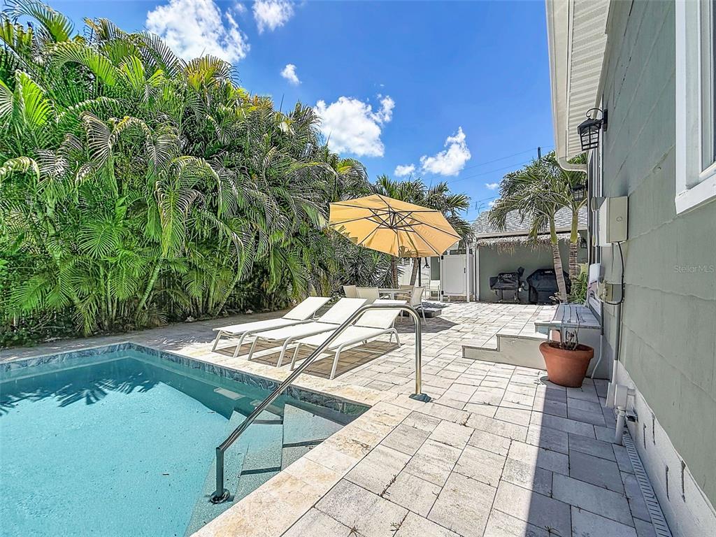 A green house with white trim is surrounded by palm trees and a grassy lawn — 182 29TH AVENUE N, ST PETERSBURG, FL