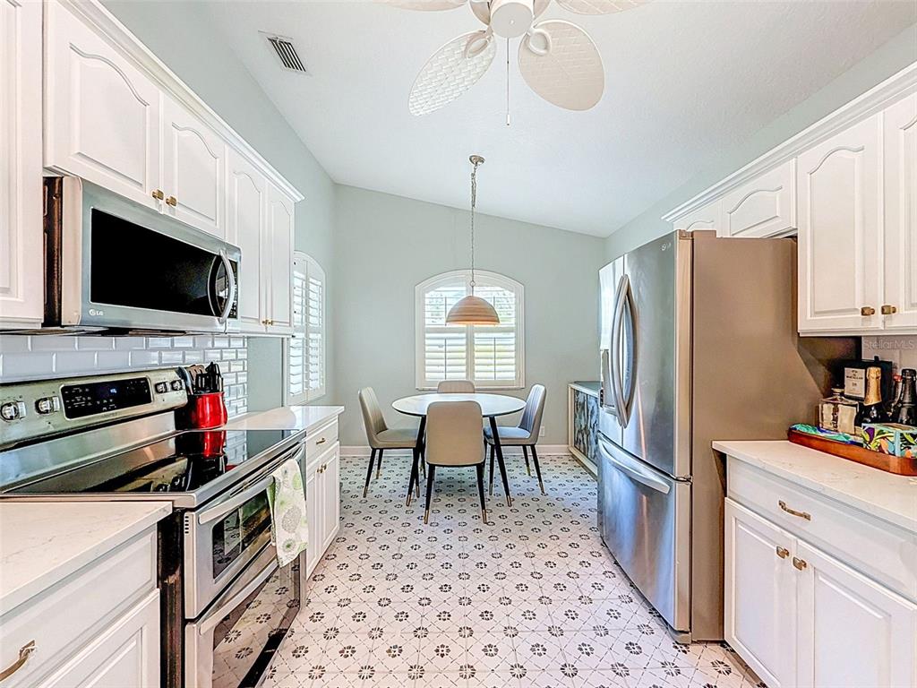 A front porch features a yellow door, a white wicker chair, and stone steps — 182 29TH AVENUE N, ST PETERSBURG, FL