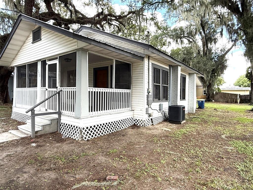 A white, single-story house with a screened-in front porch and lattice skirting — 1010 S DUDLEY AVENUE, BARTOW, FL