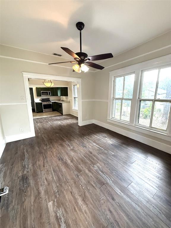A dining room with wood-look flooring and a ceiling fan opens into a kitchen — 1010 S DUDLEY AVENUE, BARTOW, FL