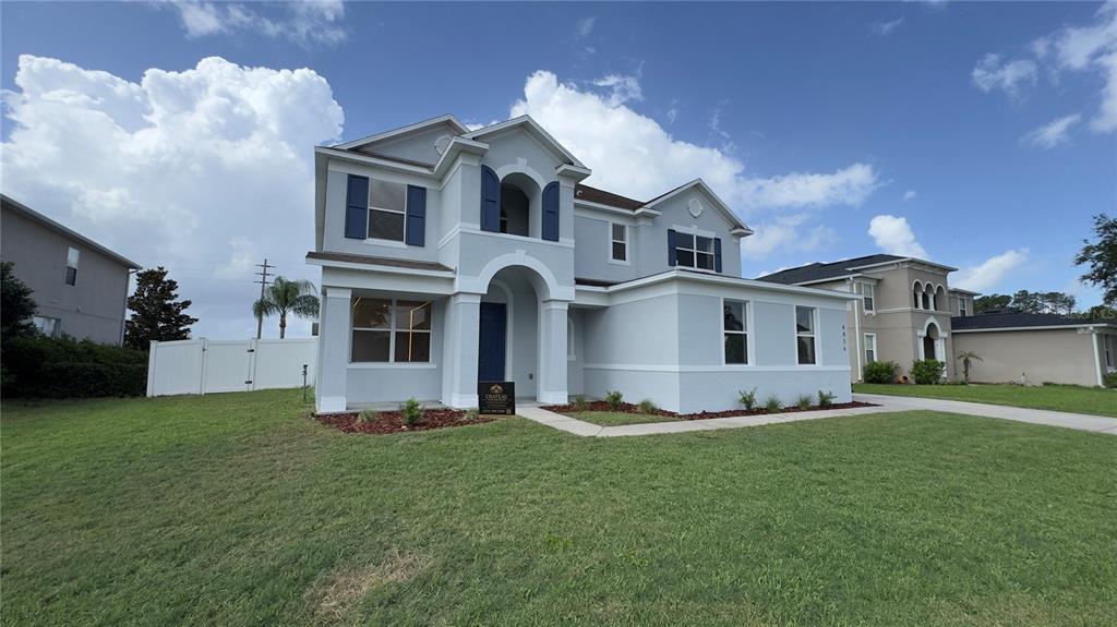 A two-story light blue house features a dark blue front door and matching window shutters — 4856 STONE ACRES CIRCLE, ST CLOUD, FL