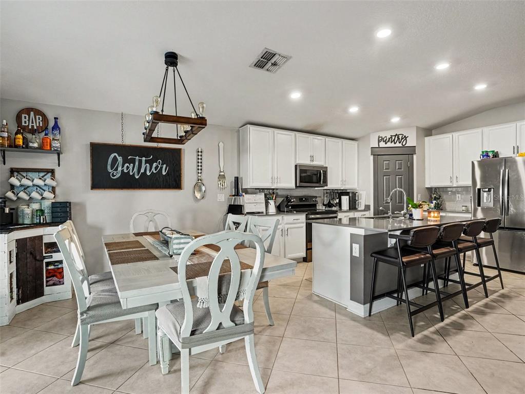 A kitchen and dining area with white cabinets, a central island, and tile flooring — 149 TAFT DRIVE, DAVENPORT, FL
