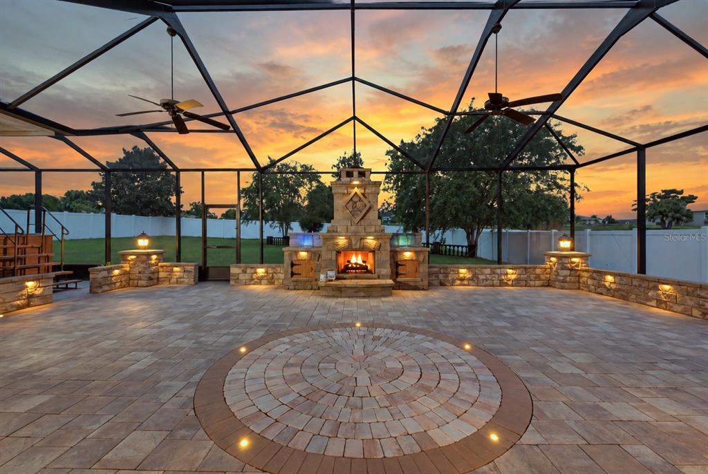 A gray single-story house with a three-car garage and a manicured front lawn — 230 LAKE ARIETTA COURT, AUBURNDALE, FL