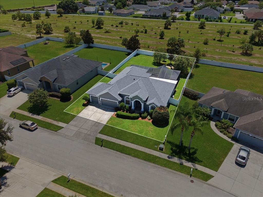 A gray house exterior features a front door with a transom window and a hedge — 230 LAKE ARIETTA COURT, AUBURNDALE, FL