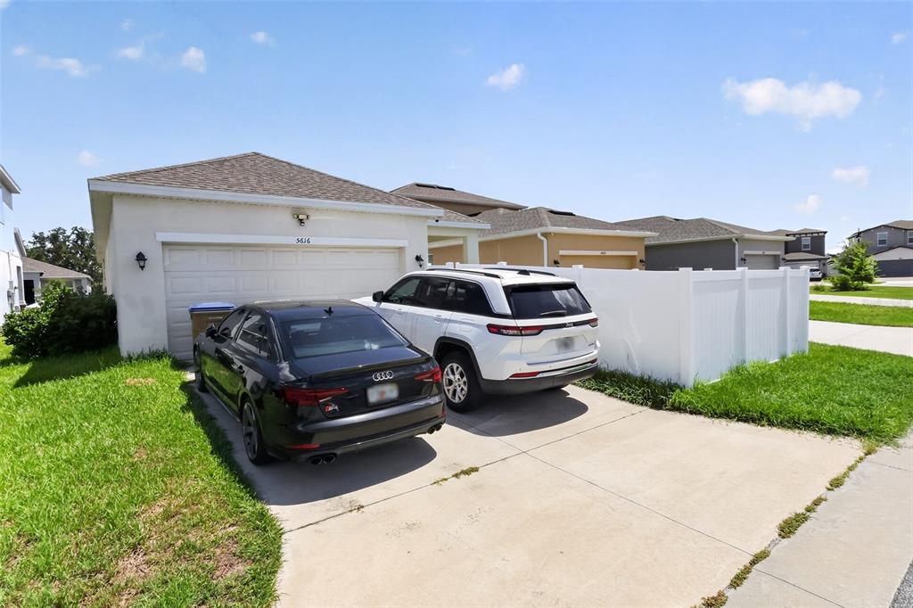 A single-story house with a two-car garage and two vehicles parked in the driveway — 5616 BEGGS ROAD, ST CLOUD, FL