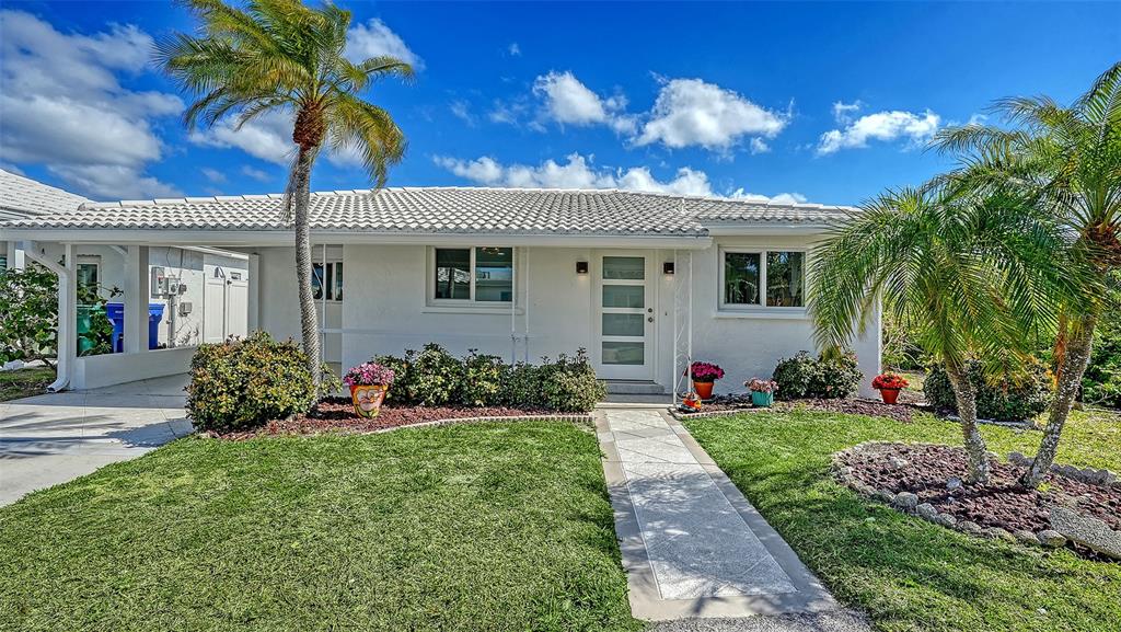 A white single-story house features a tiled roof, a front walkway, and two palm trees — 948 SPANISH DRIVE S, LONGBOAT KEY, FL