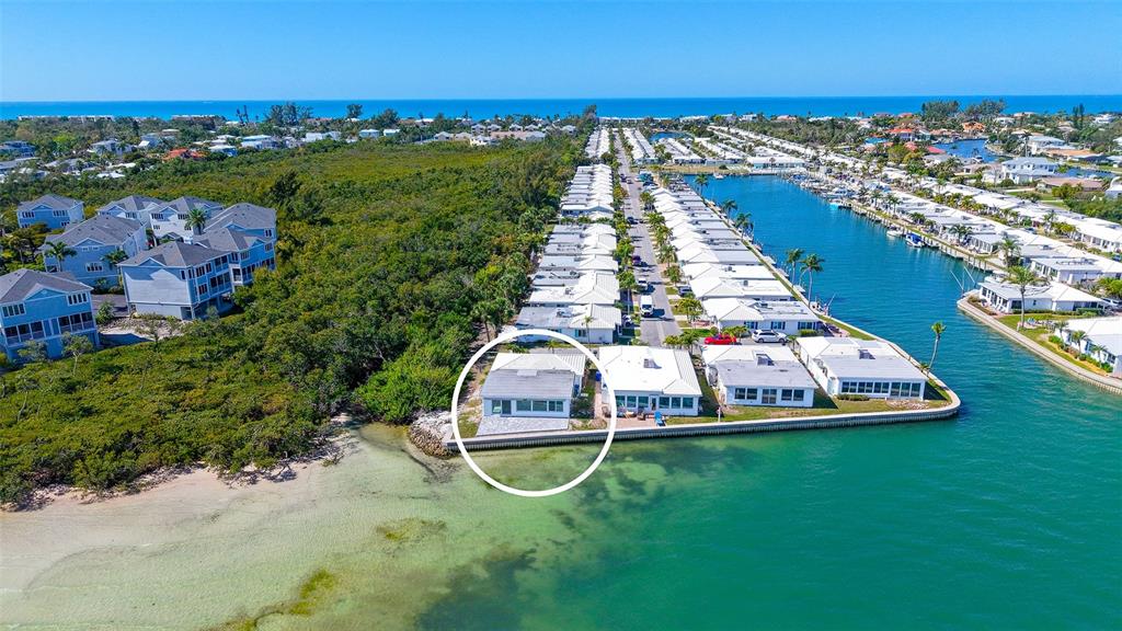 An aerial view shows a waterfront house with a white roof on a canal — 948 SPANISH DRIVE S, LONGBOAT KEY, FL
