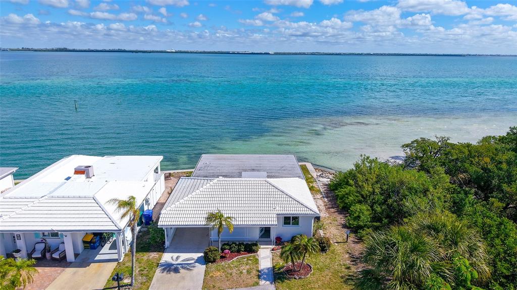 An aerial view shows two white houses situated along a clear, blue coastal shoreline — 948 SPANISH DRIVE S, LONGBOAT KEY, FL