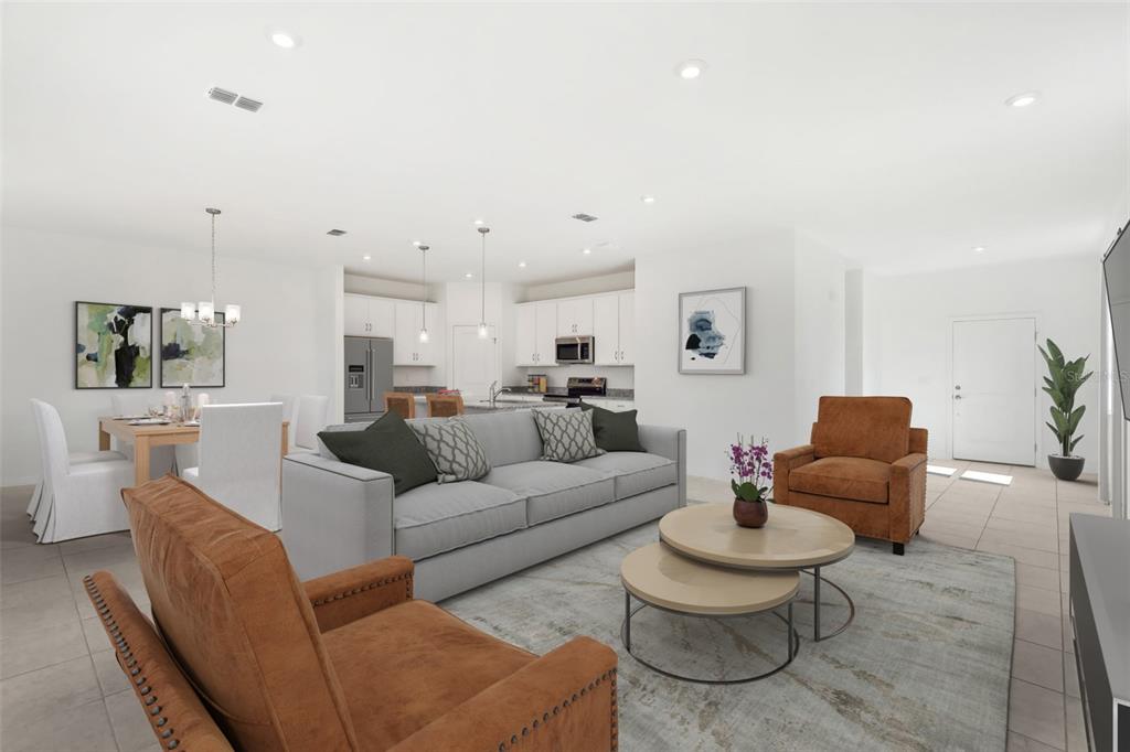 An open-concept living and dining area features a gray sofa, two brown chairs, and kitchen — 877 CASTLEFORD AVENUE NE, PALM BAY, FL