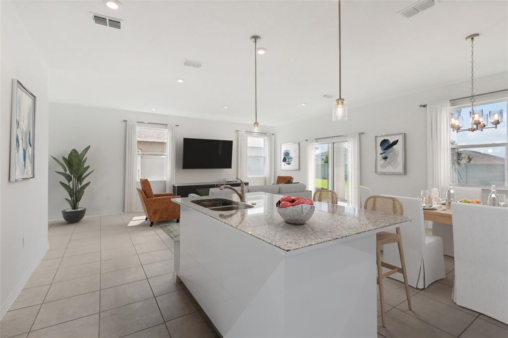 A kitchen island with granite countertops overlooks a living room and dining area — 877 CASTLEFORD AVENUE NE, PALM BAY, FL