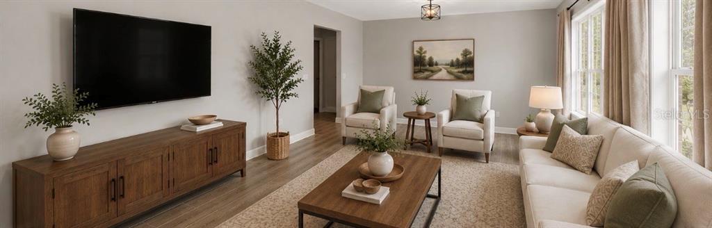 A spacious room features light wood-look flooring, a ceiling fan, and large windows with curtains — 1017 CAROLINA AVENUE, MULBERRY, FL