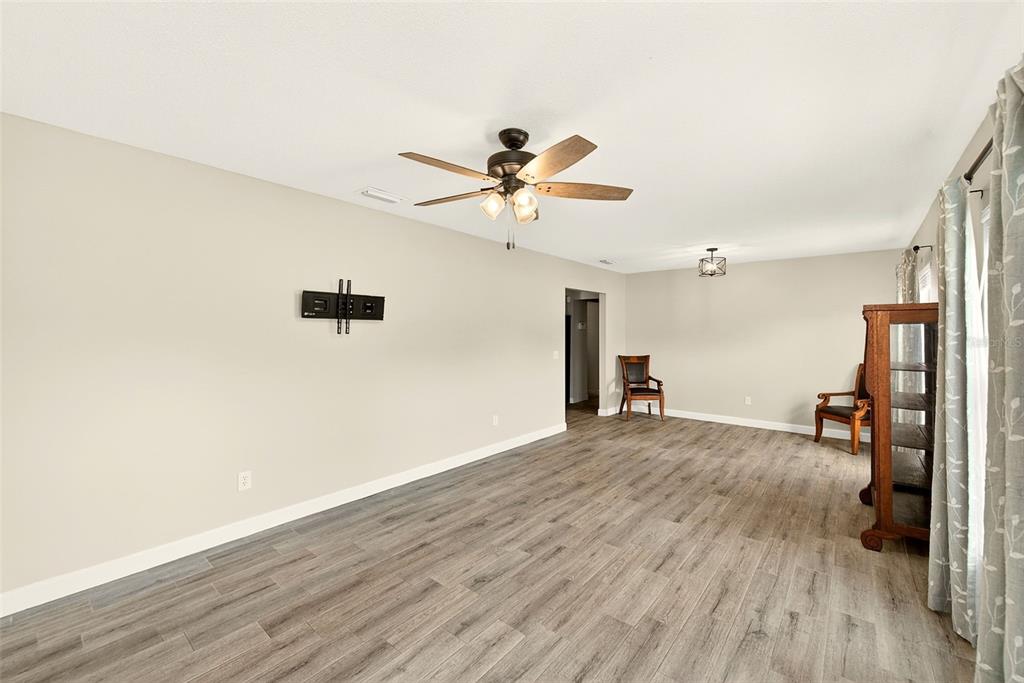 A kitchen features gray cabinets, butcher block countertops, a white farmhouse sink, and wood-look flooring — 1017 CAROLINA AVENUE, MULBERRY, FL