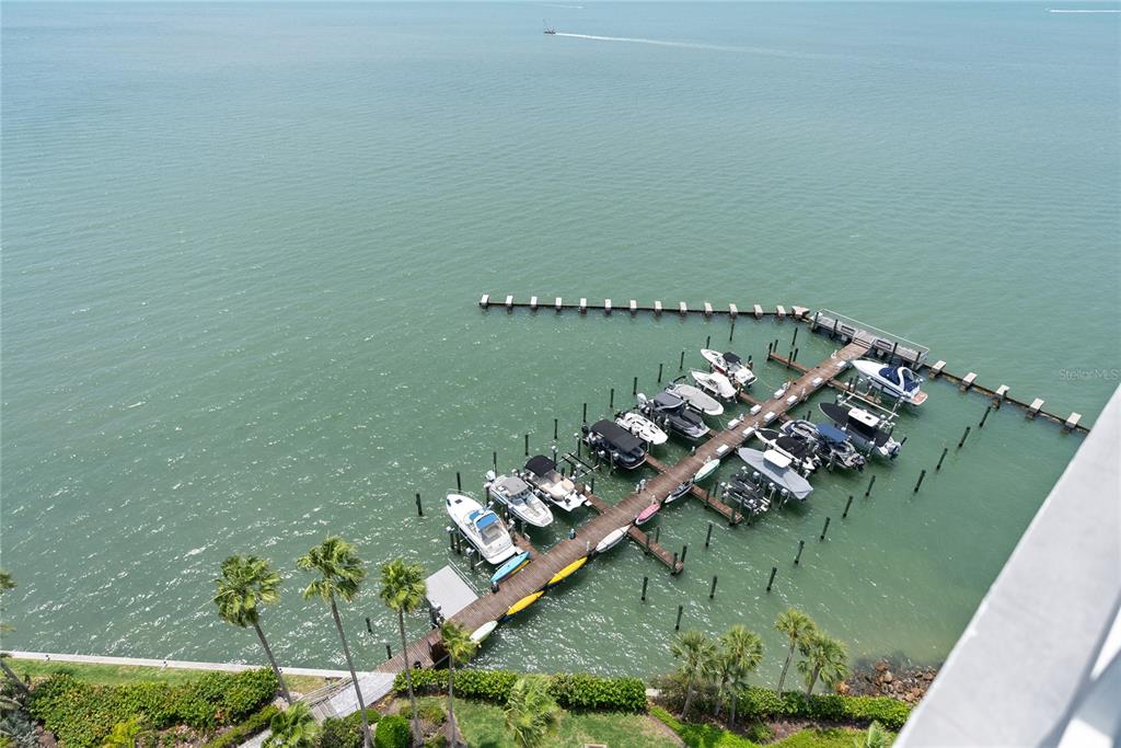 An aerial view shows a wooden boat dock with multiple docked boats in the water — 888 BOULEVARD OF THE ARTS UNIT 1705, SARASOTA, FL