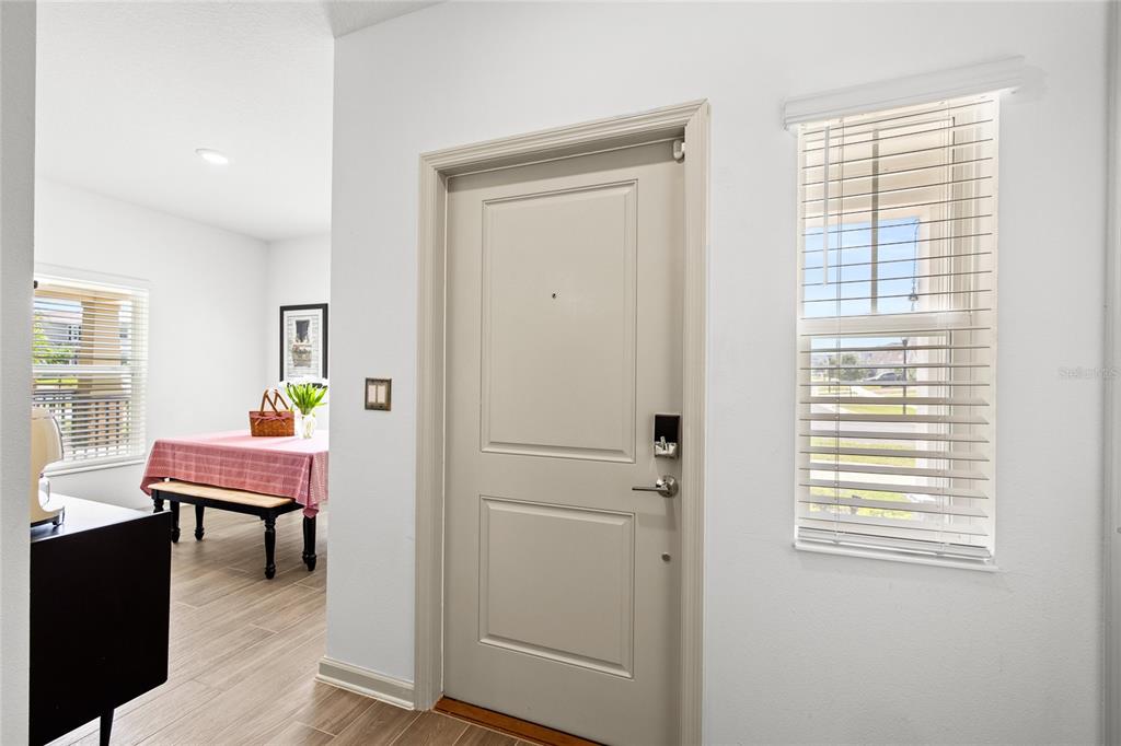 An entryway features a light-colored door, a window with blinds, and tile flooring — 6002 BLISSFUL STREET, CLERMONT, FL