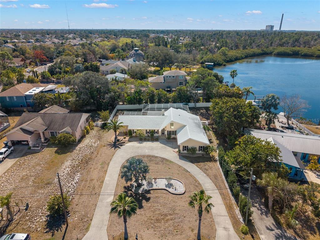 An aerial view shows a single-story house with a circular driveway and a backyard pool — 2138 BAYOU DRIVE, HOLIDAY, FL