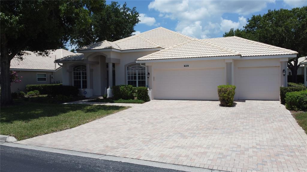 A single-story house with a light-colored tile roof and a paved driveway — 3916 SCARBOROUGH COURT, CLERMONT, FL