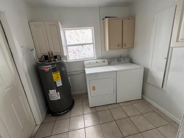 A laundry room features a water heater, a washer, a dryer, and wall-mounted cabinets — 2506 W UNION STREET, TAMPA, FL