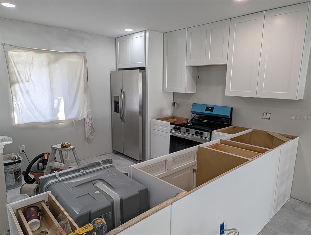 An empty bedroom features light gray tile flooring, neutral walls, and a black ceiling fan — 2888 BANCROFT CIRCLE E UNIT 5B, PALM HARBOR, FL