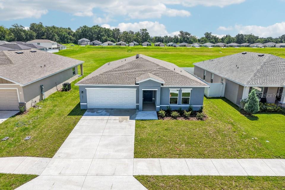 A gray single-story house with a two-car garage and a concrete driveway — 12841 SE 53RD COURT, BELLEVIEW, FL