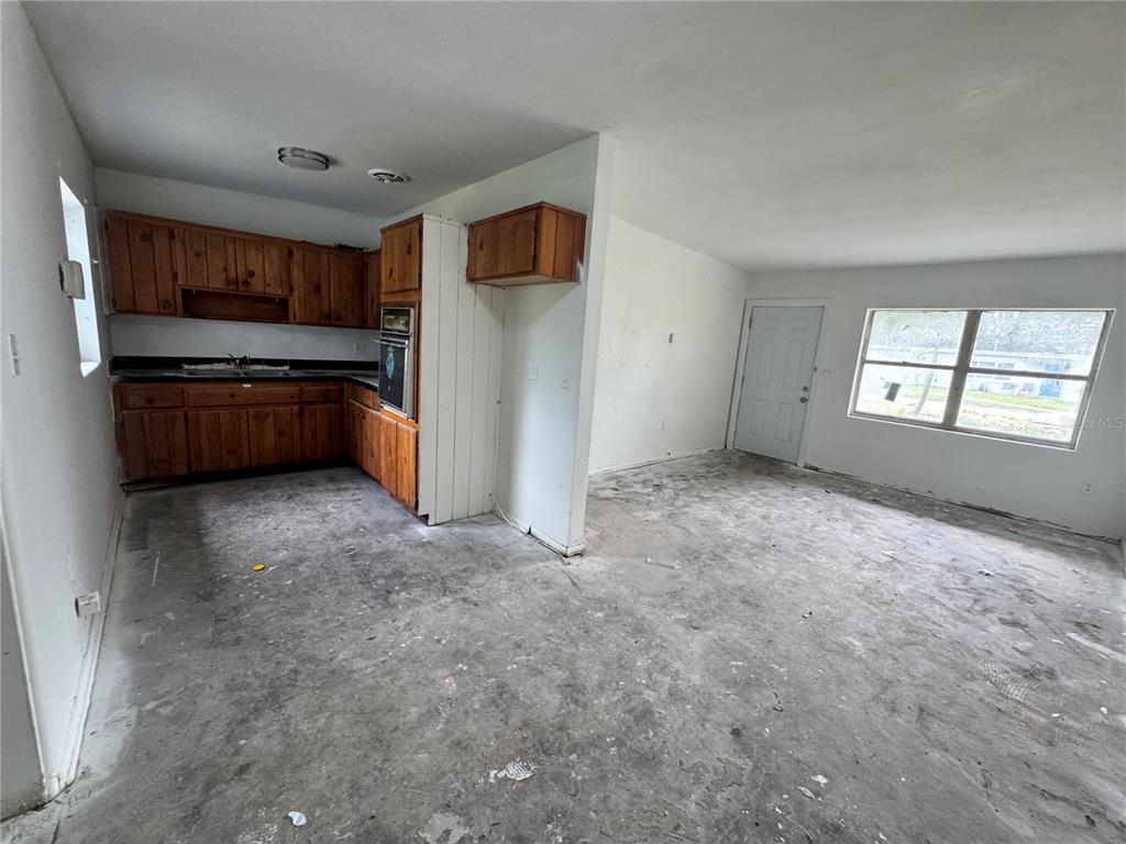 A dining room features a long wooden table with eight chairs on a jute rug — 517 MOROCCO AVENUE, ORLANDO, FL