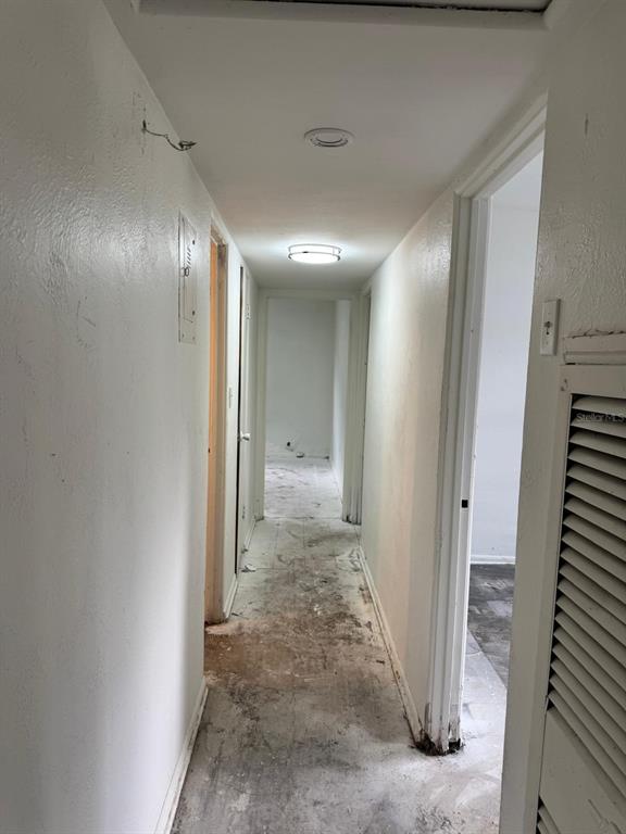 A kitchen with wood cabinets and a living area with an unfinished concrete floor — 517 MOROCCO AVENUE, ORLANDO, FL