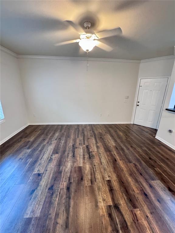 A view of an open-concept kitchen with wood cabinets and black appliances from a living area — 2249 PORTOFINO PLACE UNIT 22-2217, PALM HARBOR, FL