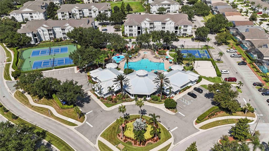 An aerial view of a community clubhouse featuring a swimming pool, tennis courts, and parking — 2382 SILVER PALM DRIVE E, KISSIMMEE, FL