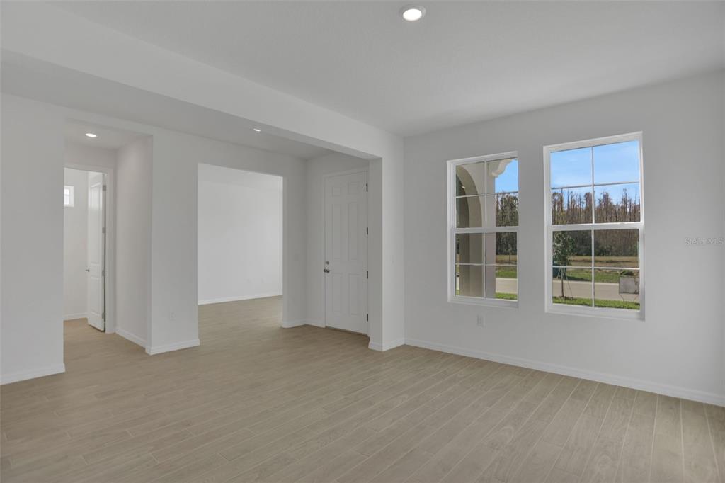 An interior view of a room with light wood-look tile flooring and two windows — 2371 JUNIPER BERRY DRIVE, MINNEOLA, FL