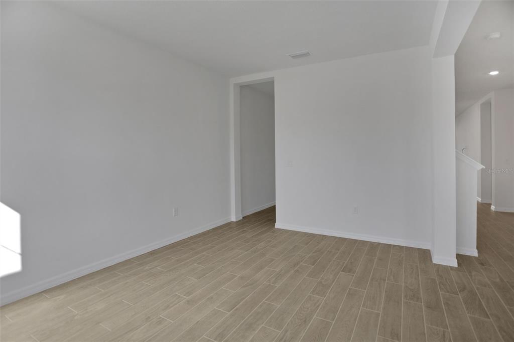 An empty room with white walls and light wood-look tile flooring — 2371 JUNIPER BERRY DRIVE, MINNEOLA, FL