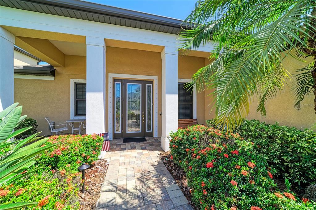A paved walkway leads to the front entrance of a house with white columns — 517 CHANTILLY TRAIL, BRADENTON, FL