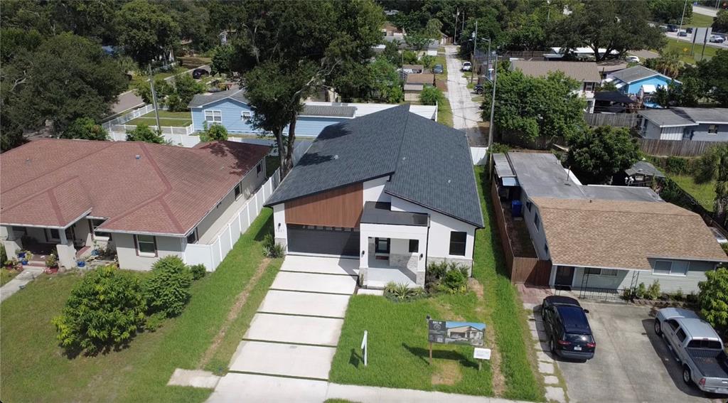 A modern single-story house with a wood-paneled garage, stone accents, and a concrete driveway — 2227 32ND AVENUE N, ST PETERSBURG, FL