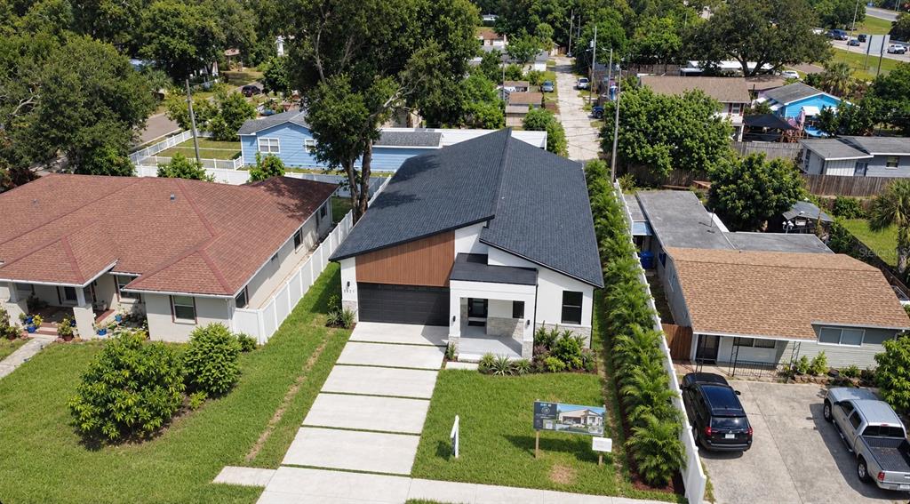 A modern home exterior features a covered porch, stone veneer base, and a glass front door — 2227 32ND AVENUE N, ST PETERSBURG, FL