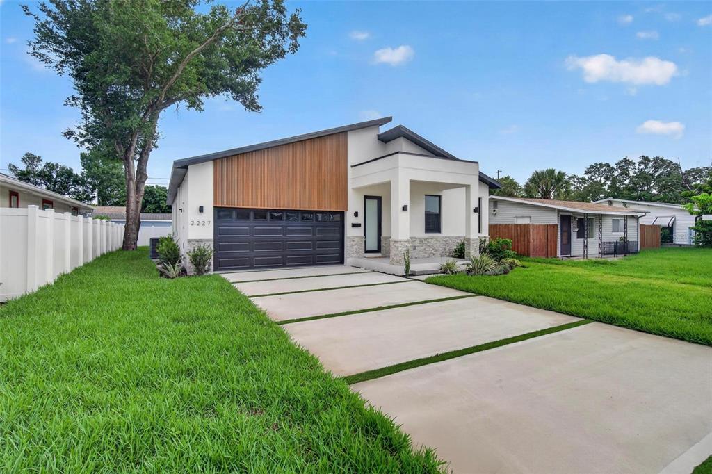 A narrow hallway with light gray walls, white baseboards, tile flooring, and a black-framed door — 2227 32ND AVENUE N, ST PETERSBURG, FL