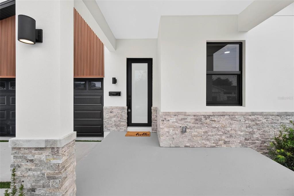An open-concept kitchen and living area with a marble island, dining table, and neutral flooring — 2227 32ND AVENUE N, ST PETERSBURG, FL