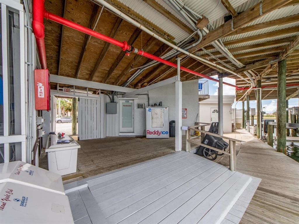 A covered wooden dock area features a Reddy Ice machine, fire equipment, and a ramp — 200 WINDWARD PASSAGE UNIT 66, CLEARWATER BEACH, FL