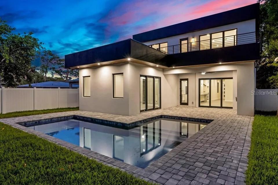 A modern two-story house features a dark garage door, white stucco walls, and flat roofline — 2475 BAY STREET, SARASOTA, FL