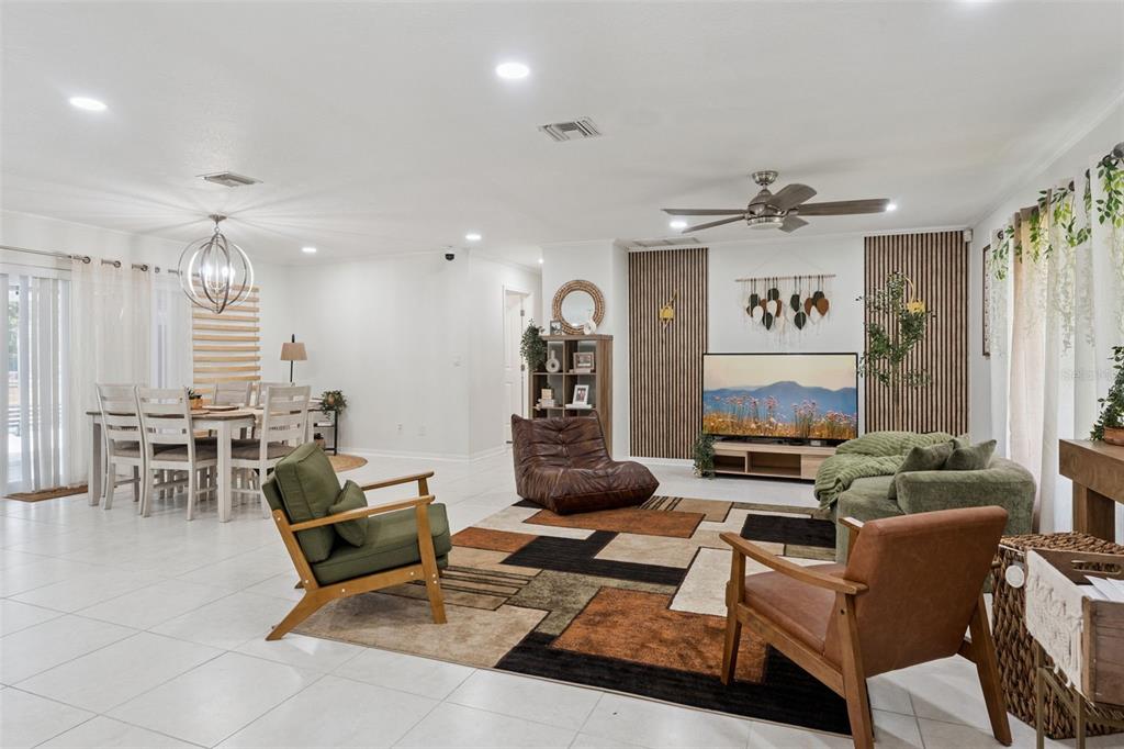 A living and dining area features white tile floors, wood slat wall accents, and modern furniture — 1756 TANGLEWOOD DRIVE, KISSIMMEE, FL