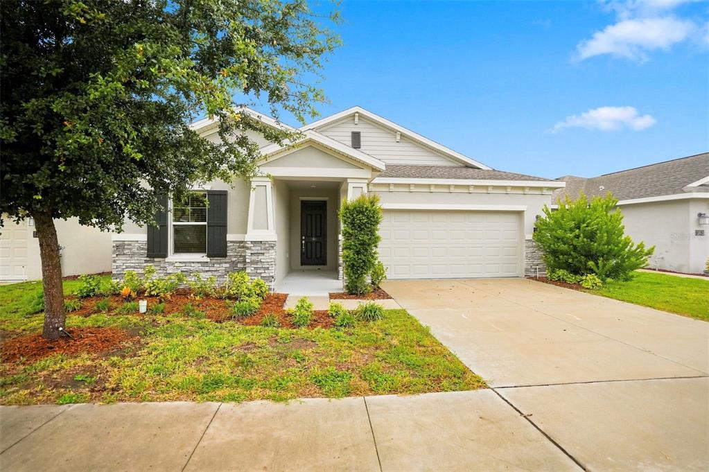 A single-story suburban house features a stone facade, a two-car garage, and a front porch — 139 PERSHING STREET, BARTOW, FL