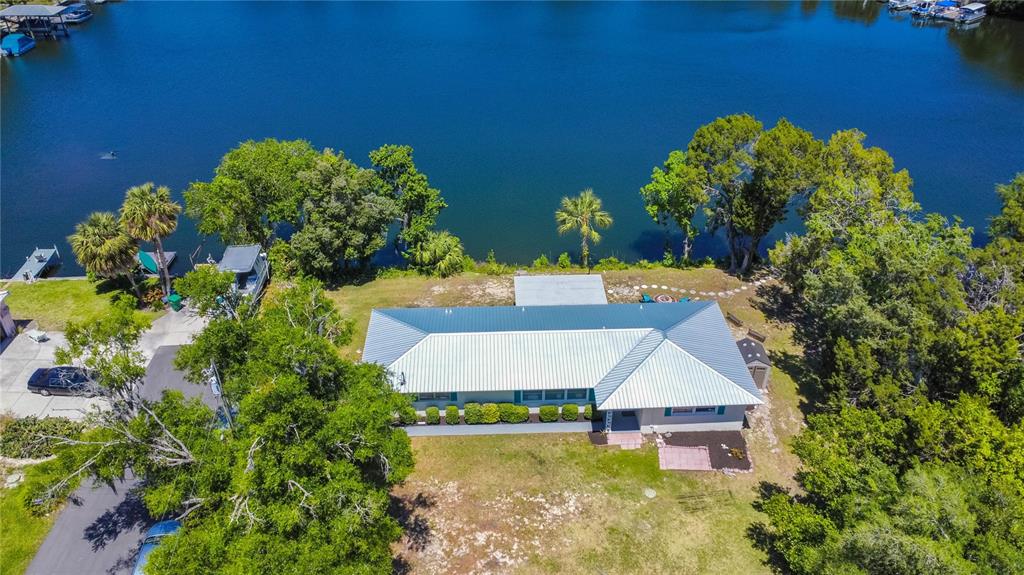 An aerial view shows a house with a metal roof situated on a waterfront lot — 3861 N RINGDOVE POINT, CRYSTAL RIVER, FL