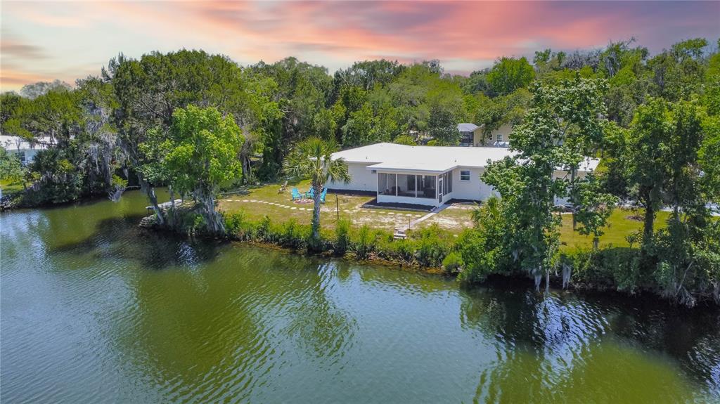An aerial view of a white house with a screened porch situated on a riverbank — 3861 N RINGDOVE POINT, CRYSTAL RIVER, FL