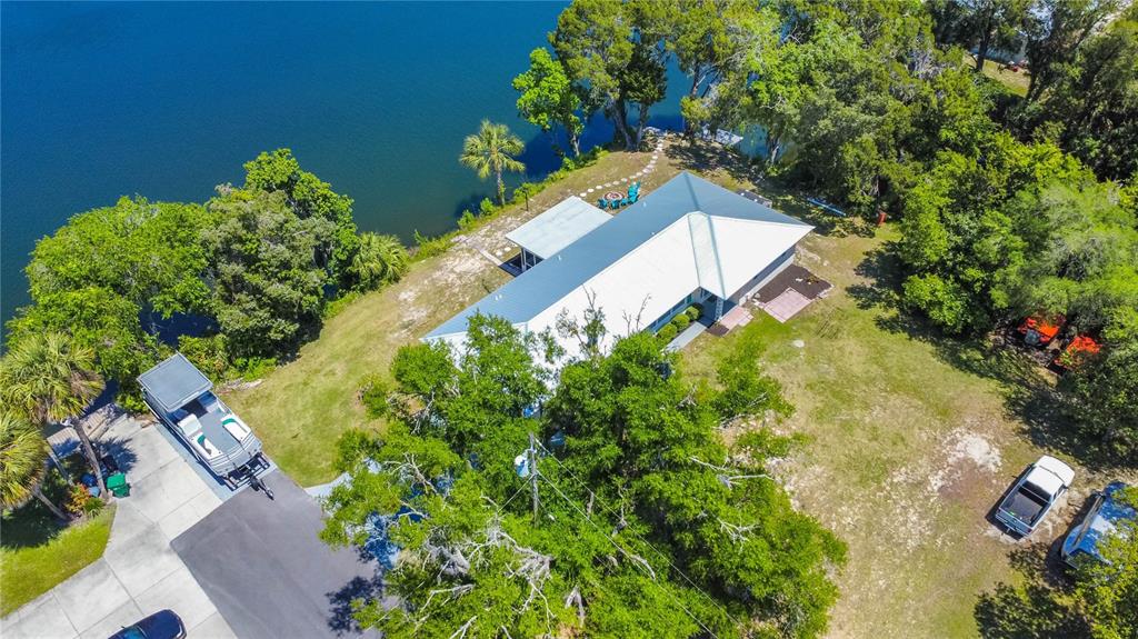 An aerial view shows a house with a metal roof situated on a waterfront lot — 3861 N RINGDOVE POINT, CRYSTAL RIVER, FL