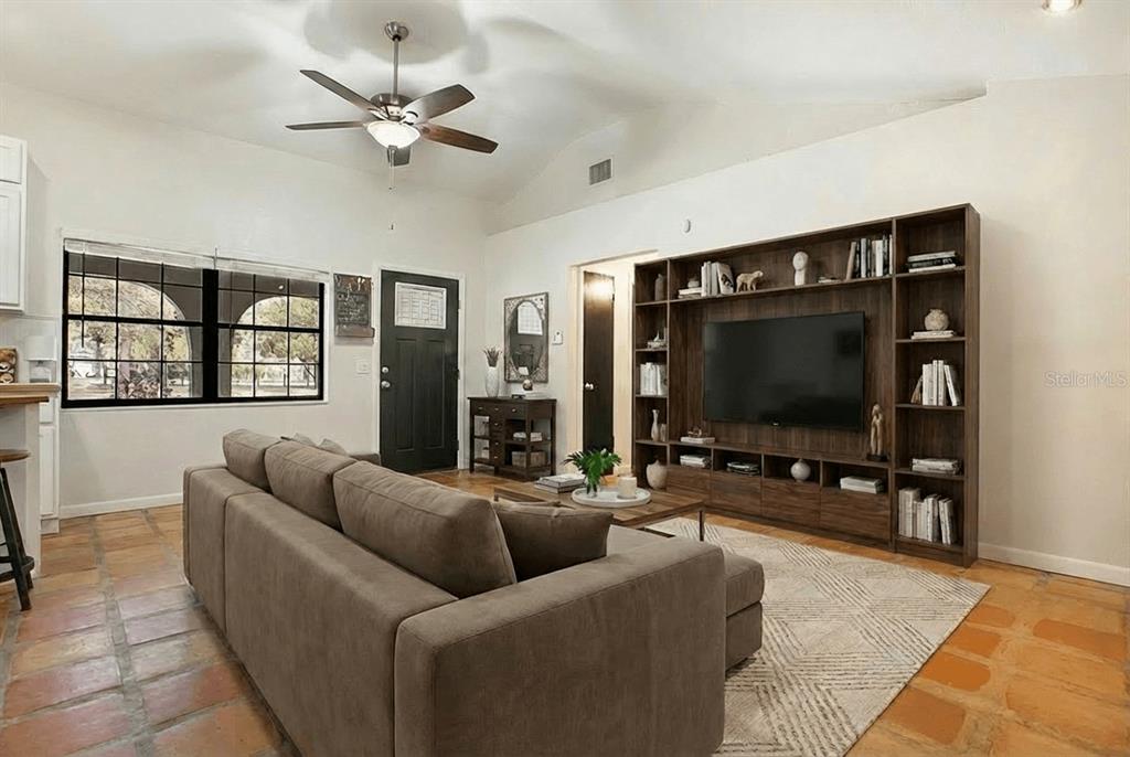 A living room features a large brown sectional, a built-in media center, and terracotta flooring — 3116 E BUCK, INVERNESS, FL