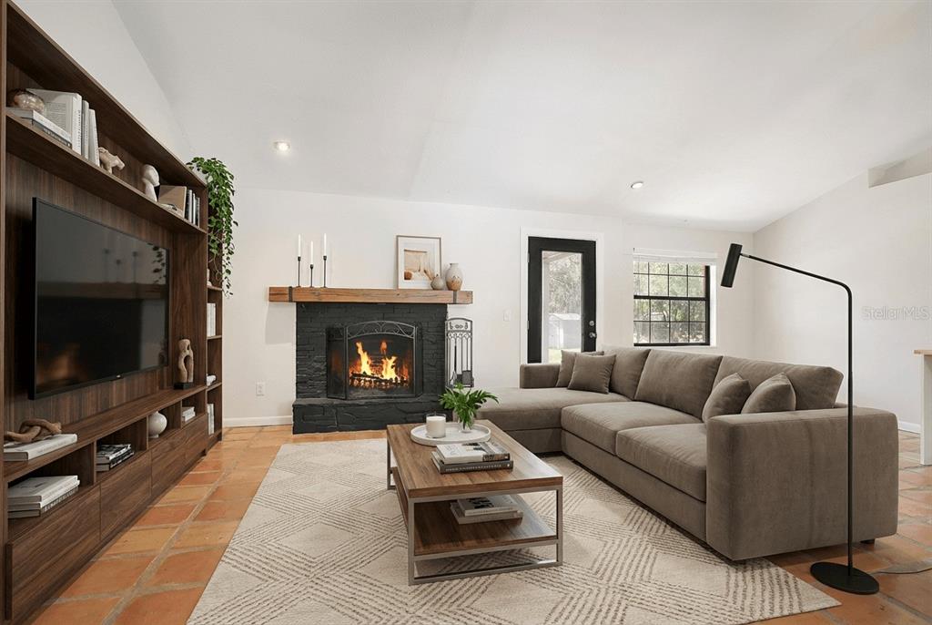 A living room features a black stone fireplace, a brown sectional sofa, and wood shelving — 3116 E BUCK, INVERNESS, FL