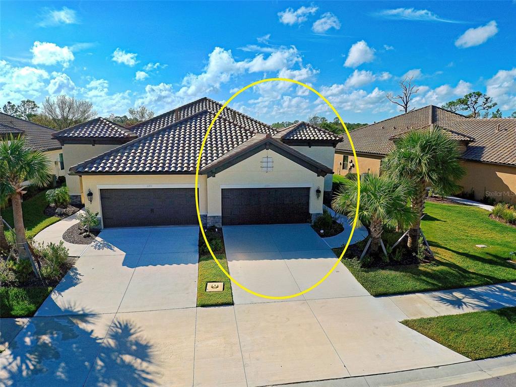 An aerial view shows the exterior of a suburban home with a two-car garage — 233 PALIDORO CIRCLE, NOKOMIS, FL