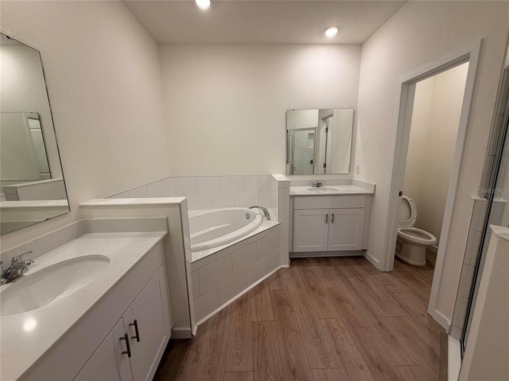A modern kitchen features white cabinetry, stainless steel appliances, and a large central island — 3042 KINGSMAN TRAIL, ORMOND BEACH, FL